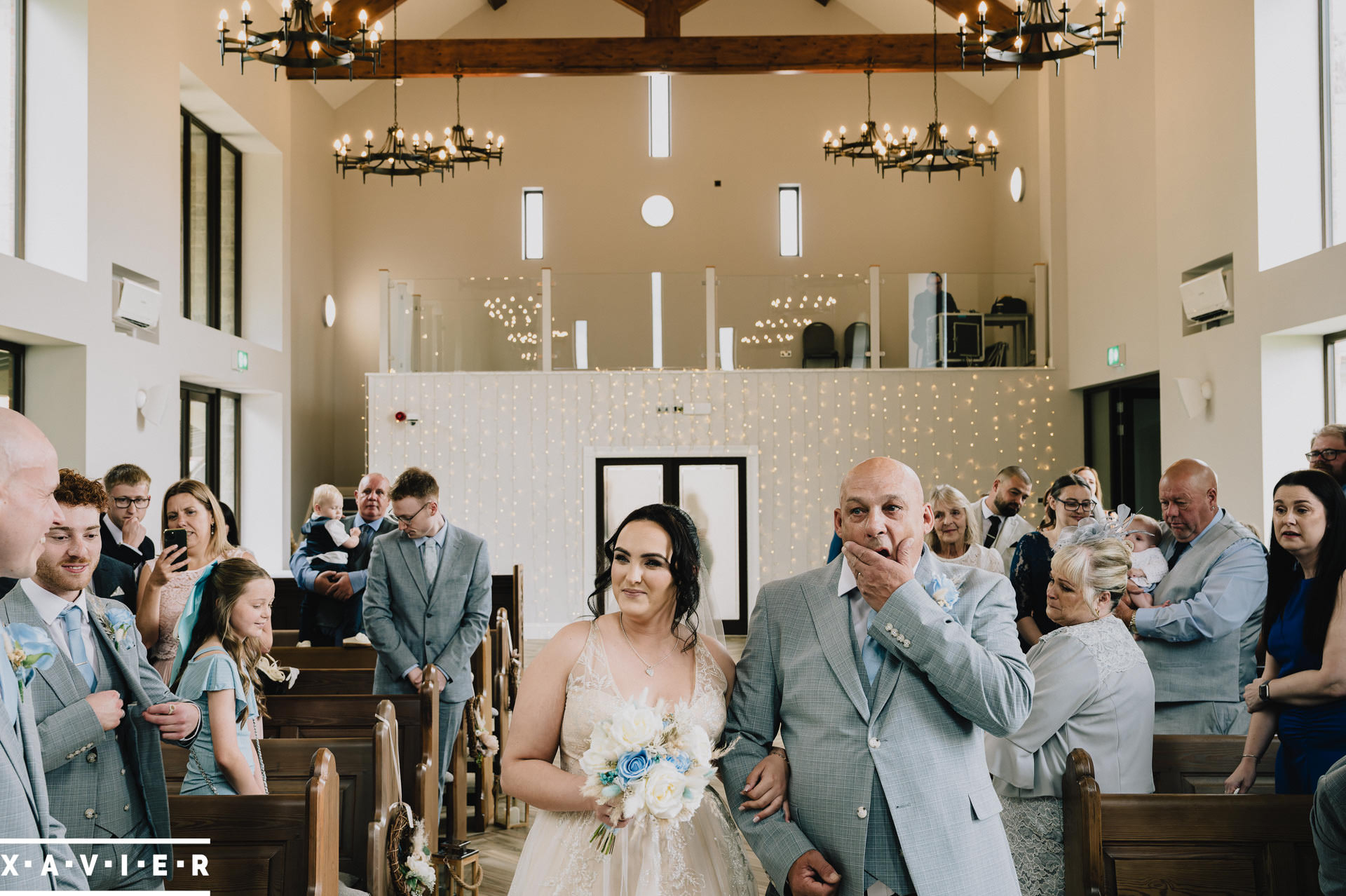bride and father walk up the aisle together