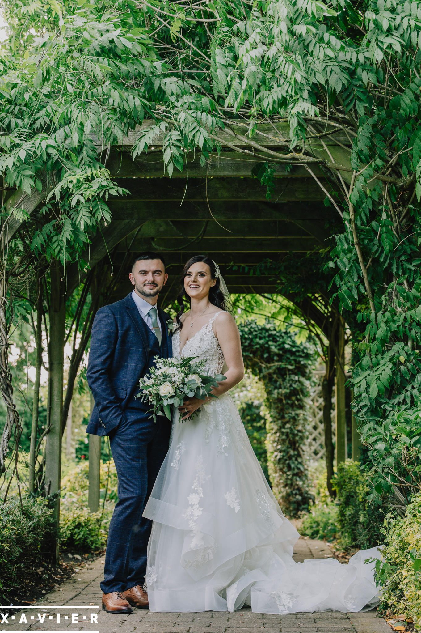 bride and groom stand in the woodland