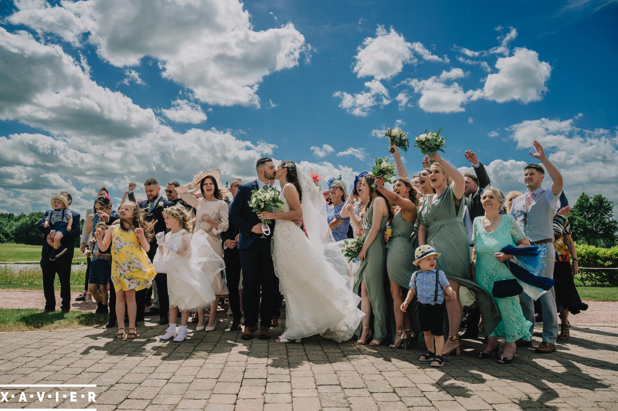 wedding guests stand aournd the couple and wave