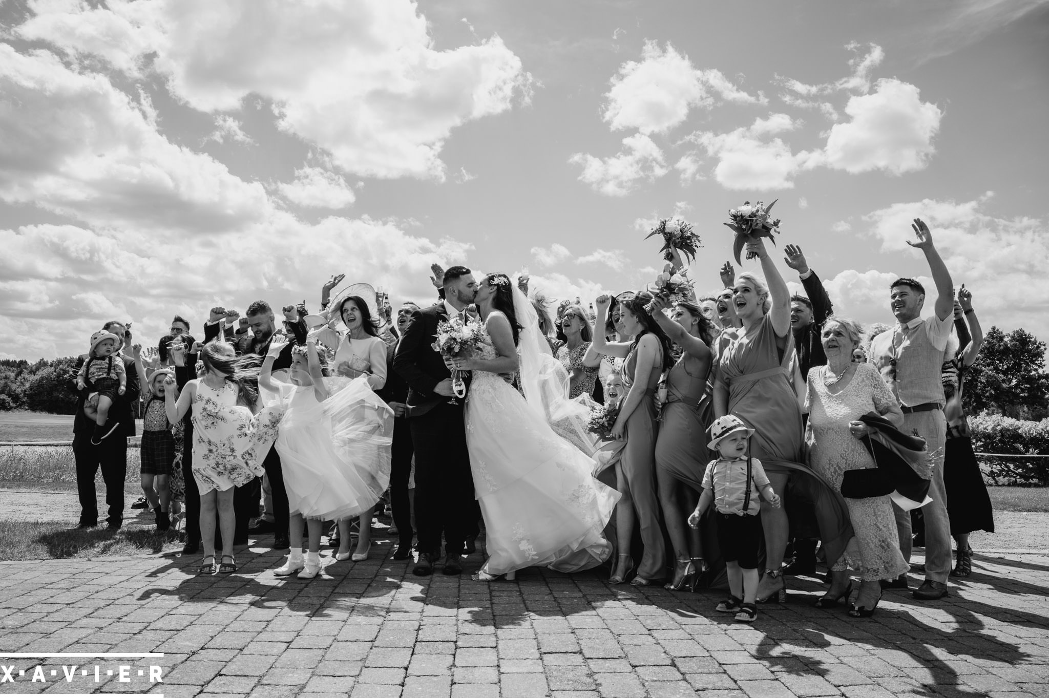 bride and groom kiss as guests surround them