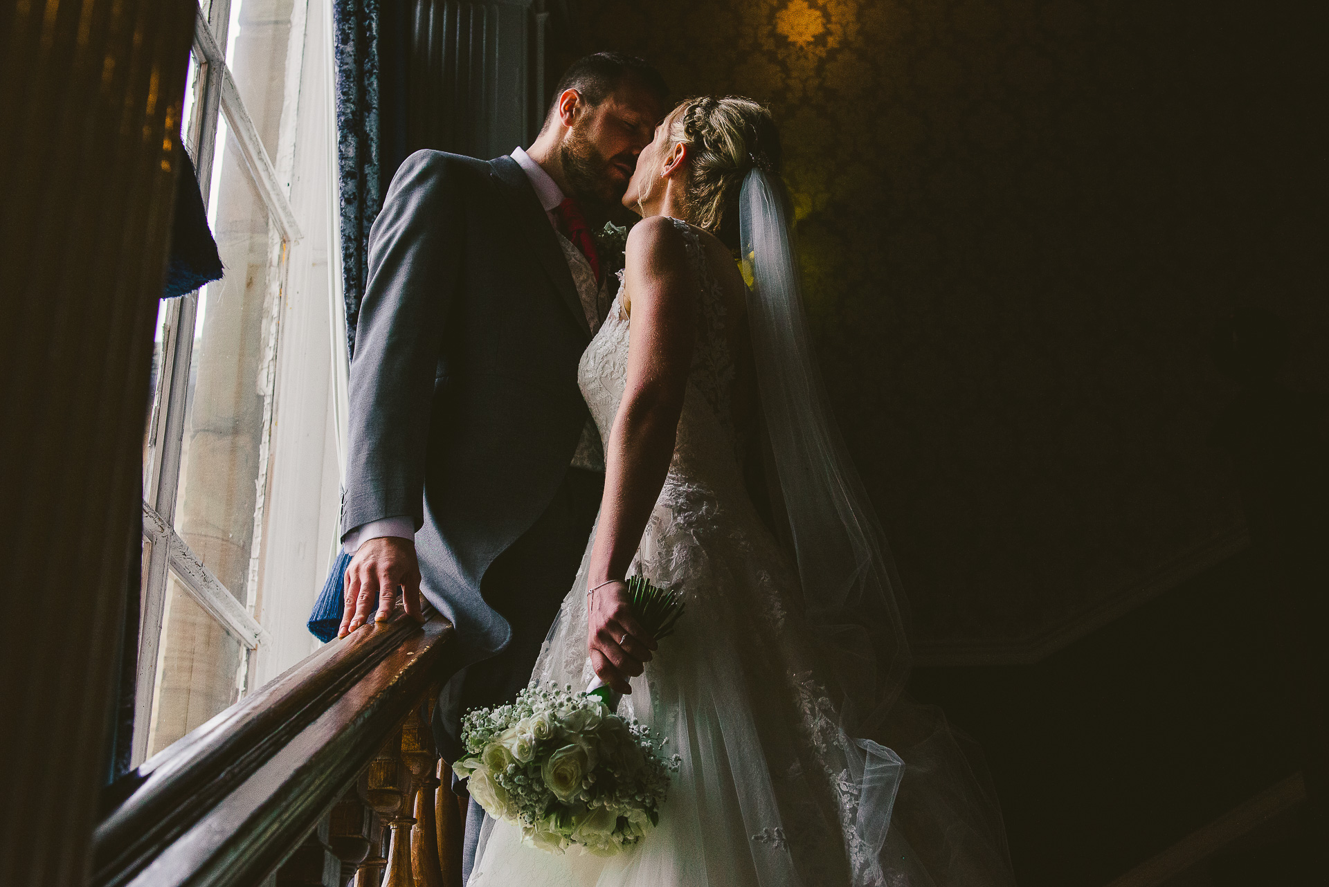 bride and groom kiss on the stairs