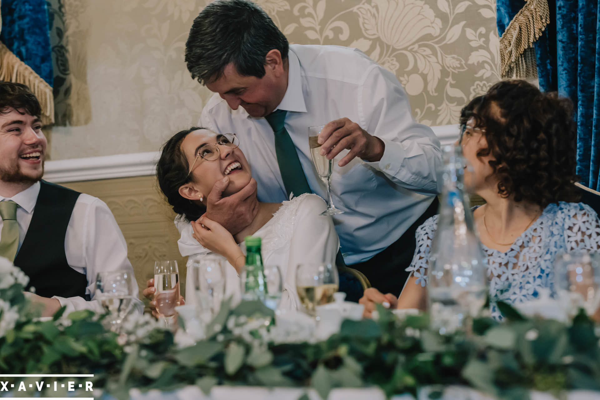 father hugs bride during speeches