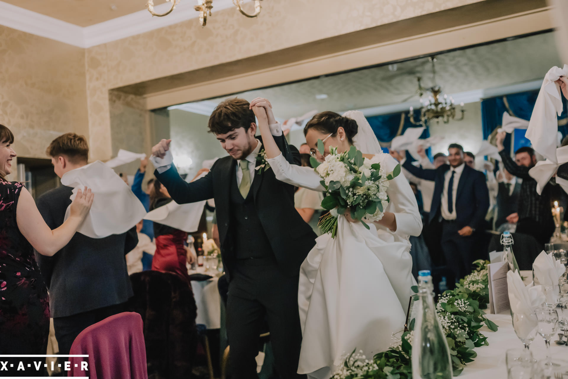 bride and groom enter wedding breakfast room