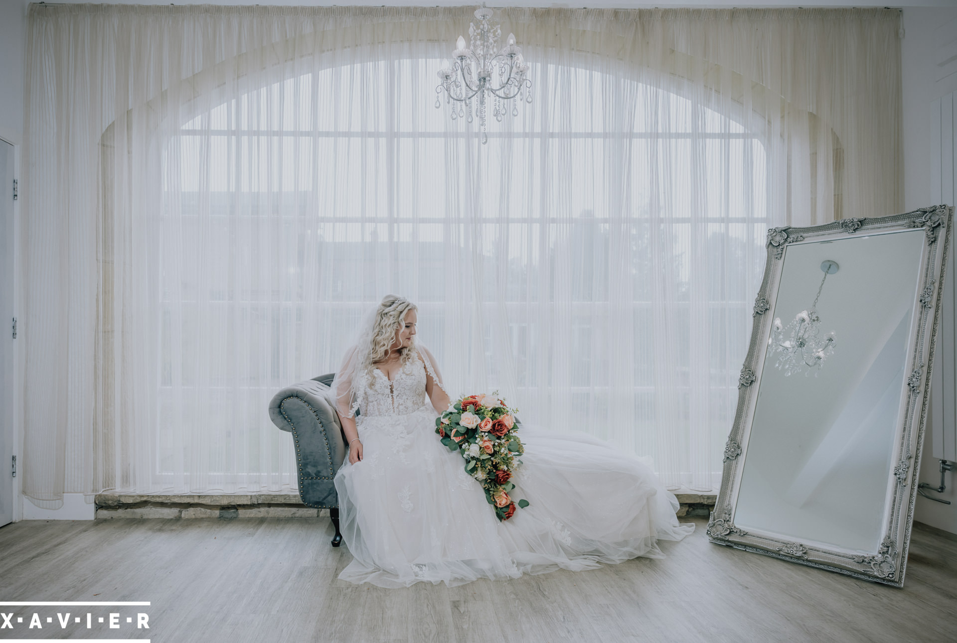 bride poses on the chaise long with flowers