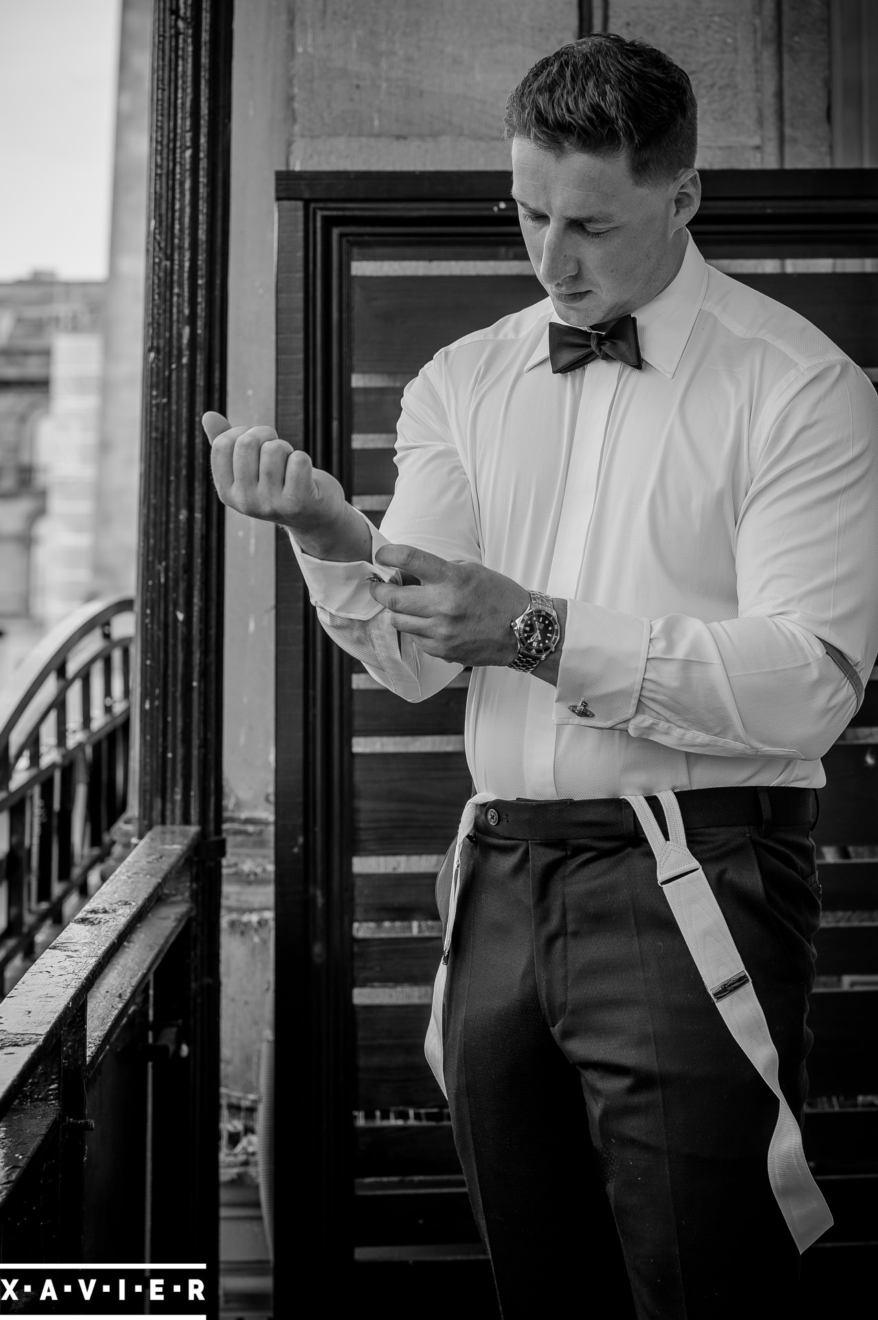 groom fastens his cuff links