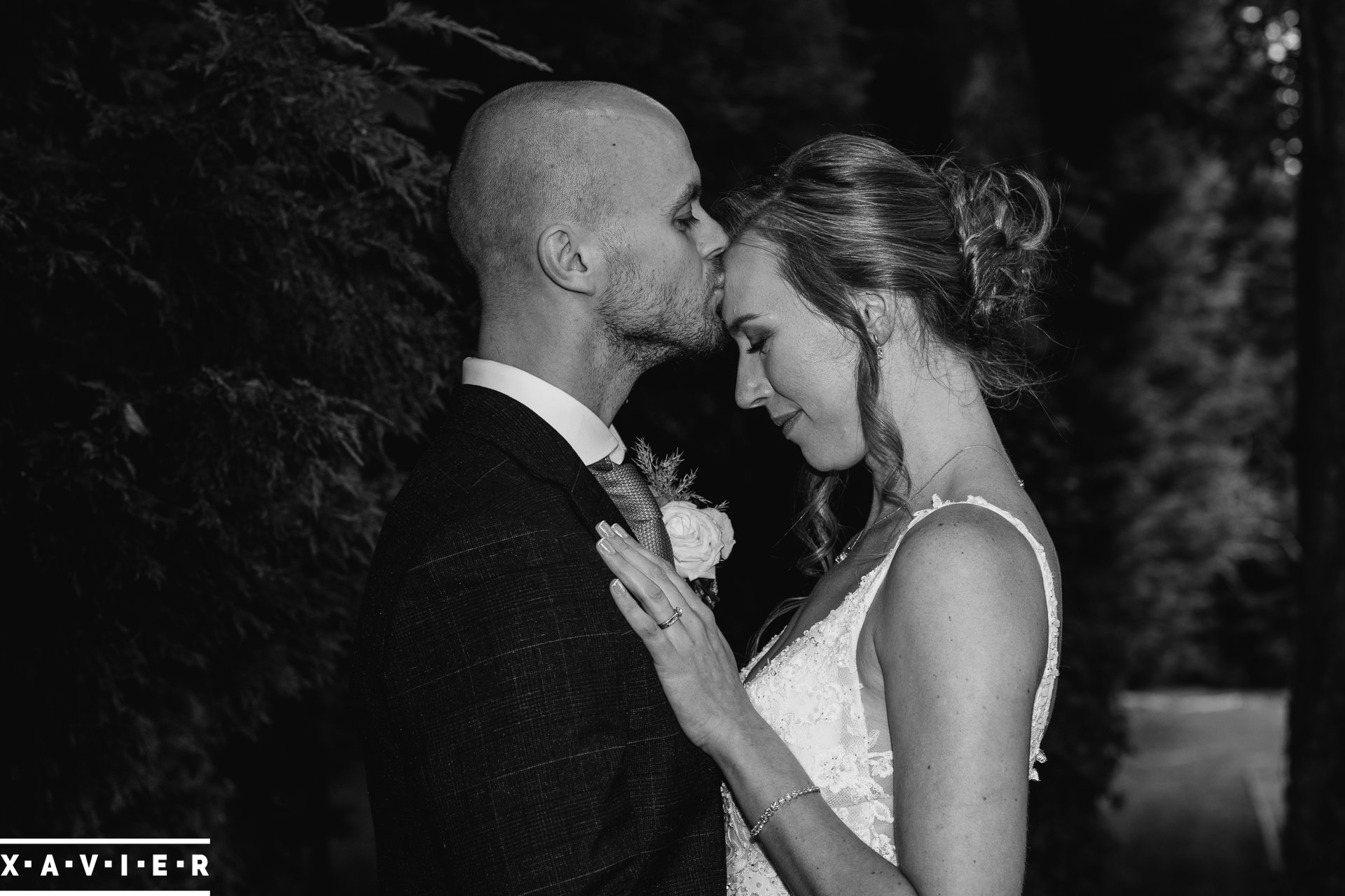 bride an dgroom kiss under the trees