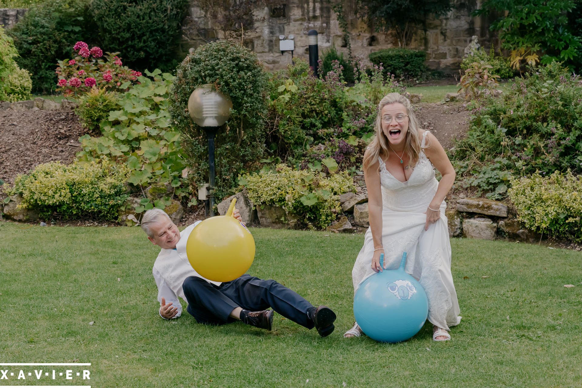 bride and groom playing on spacehoppers