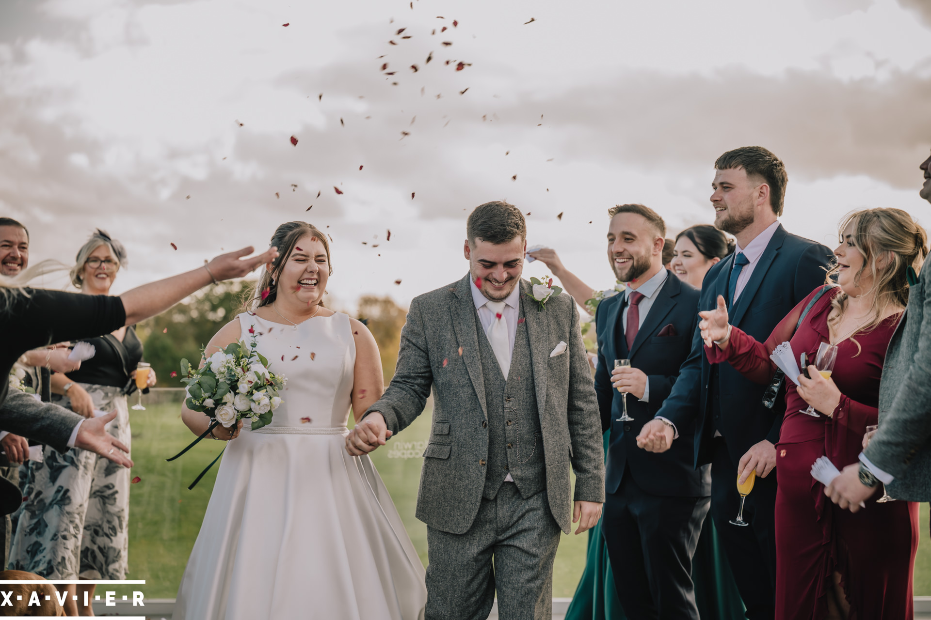 Bride and groom walk the confetti tunnel
