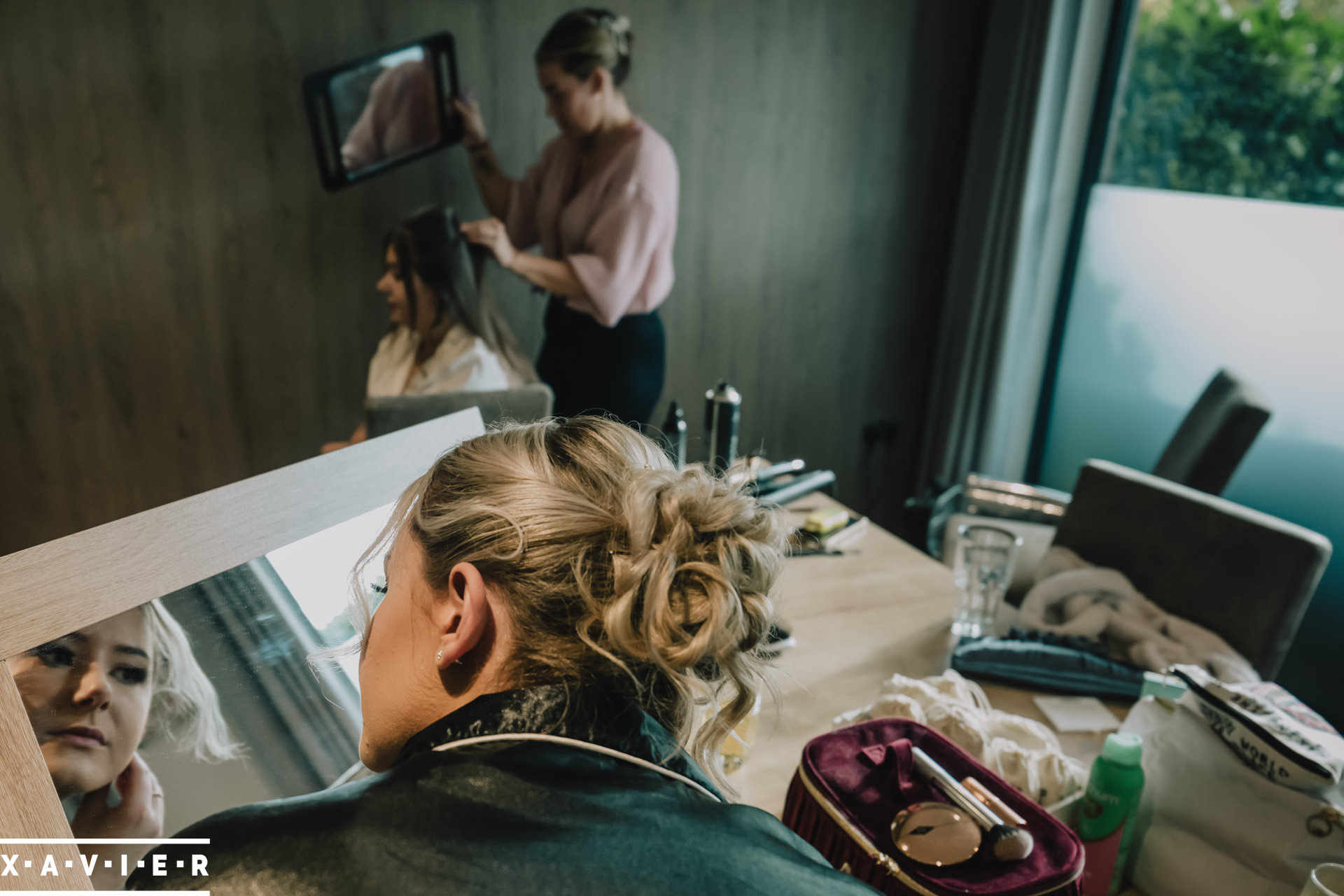 bridesmaid looks in the mirror whilst putting on earrings