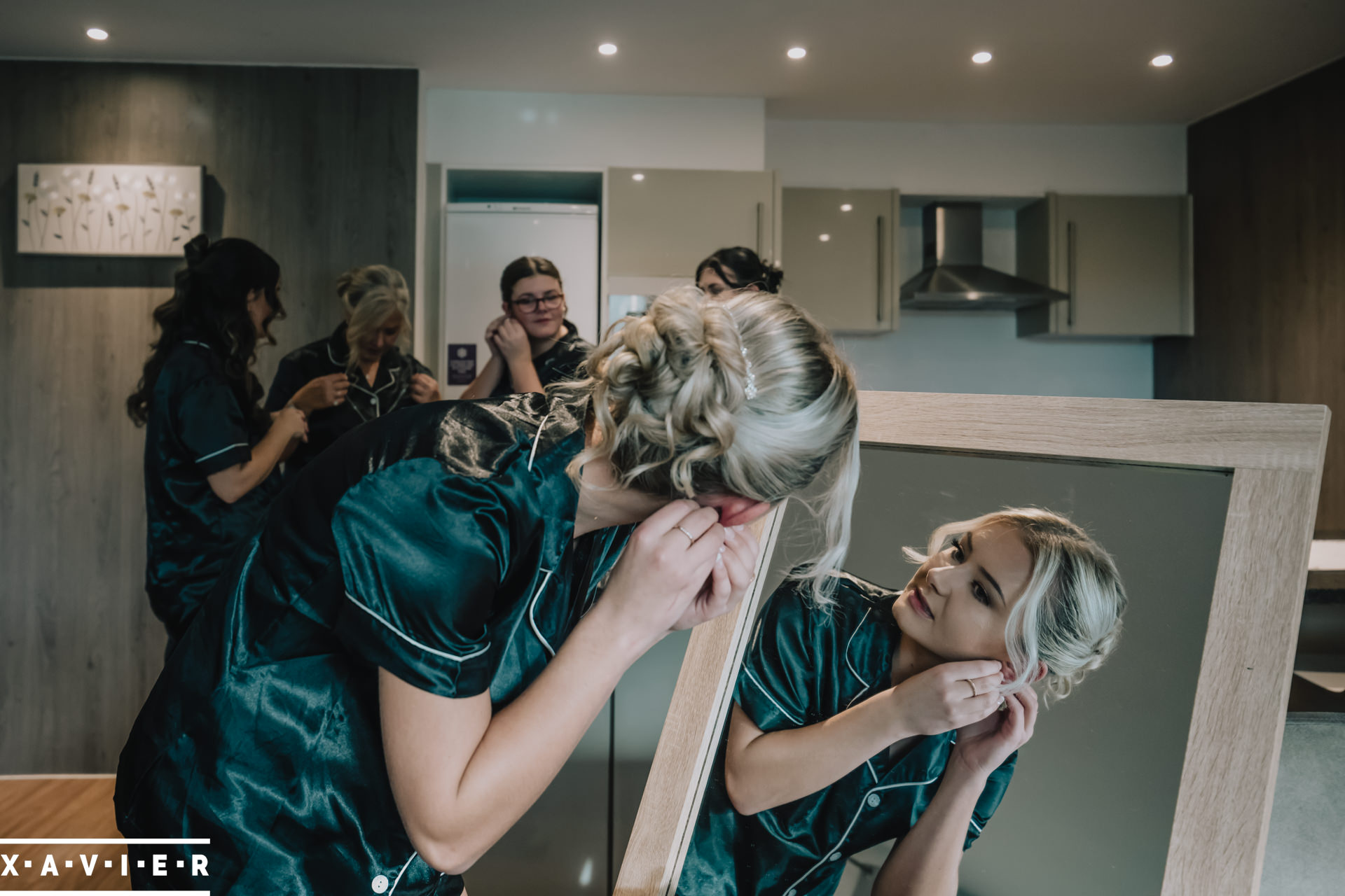 bridesmaid looks in the mirror whilst putting on earrings