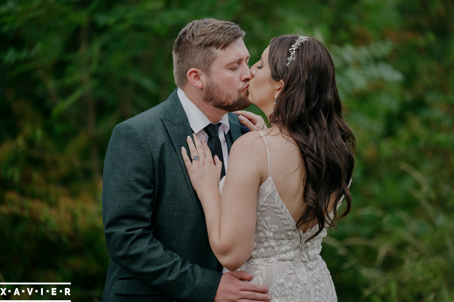 bride and groom kissing in the grounds of the manor house