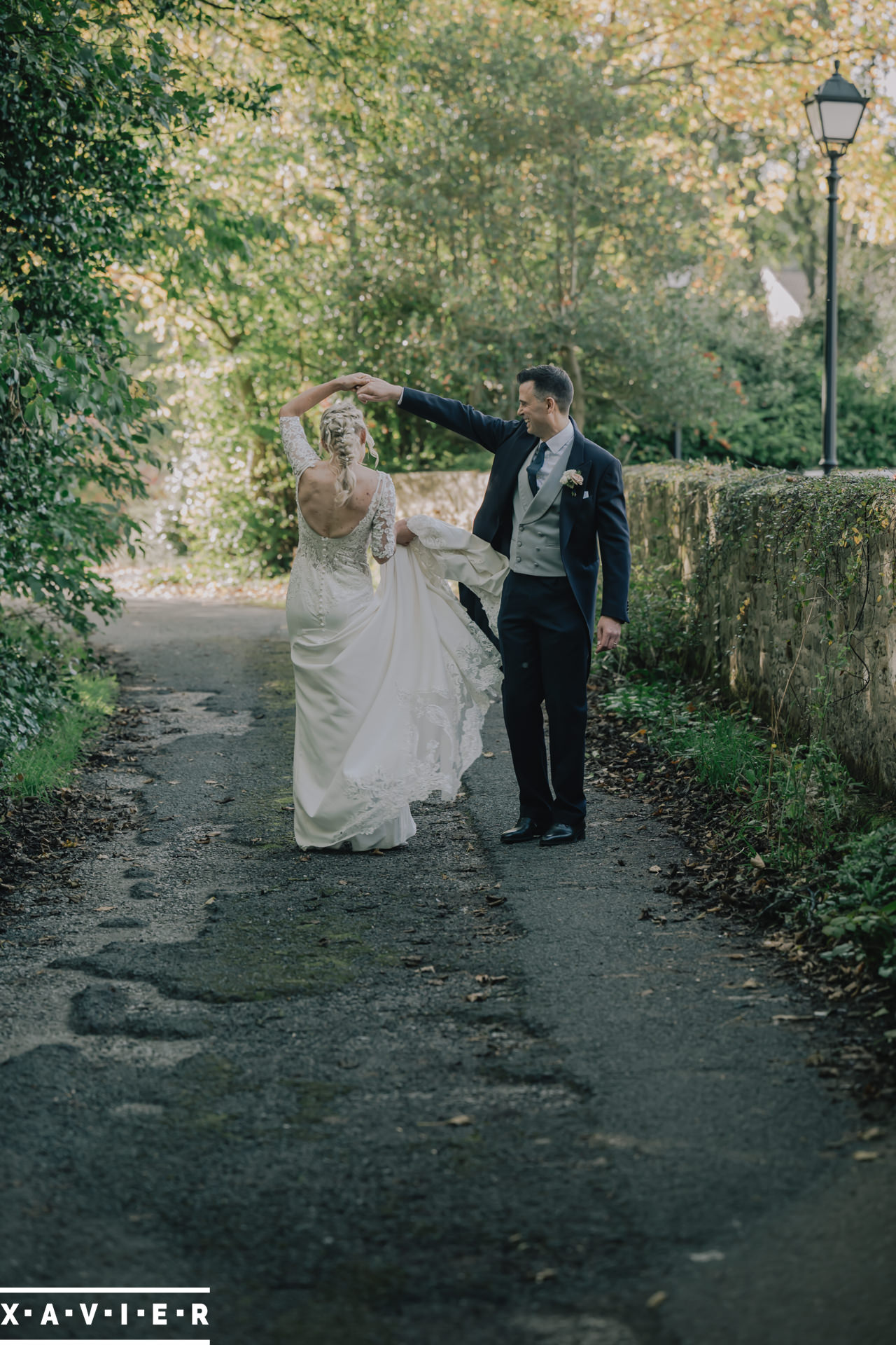 bride and groom do a twirl on the path
