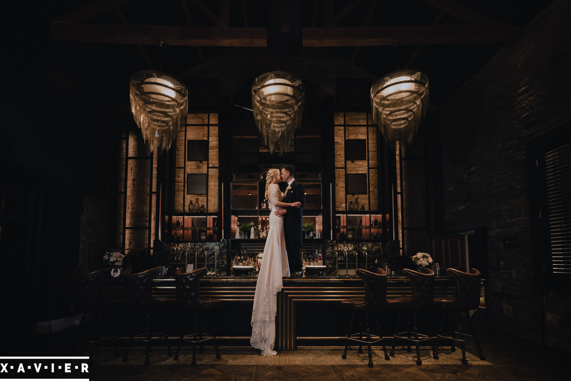 bride and groom kiss on the bar