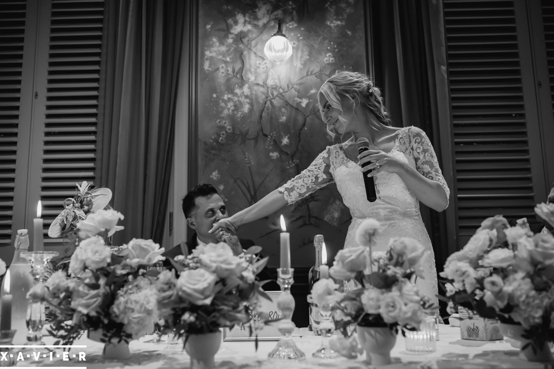 bride kisses the grooms hand during the speeches