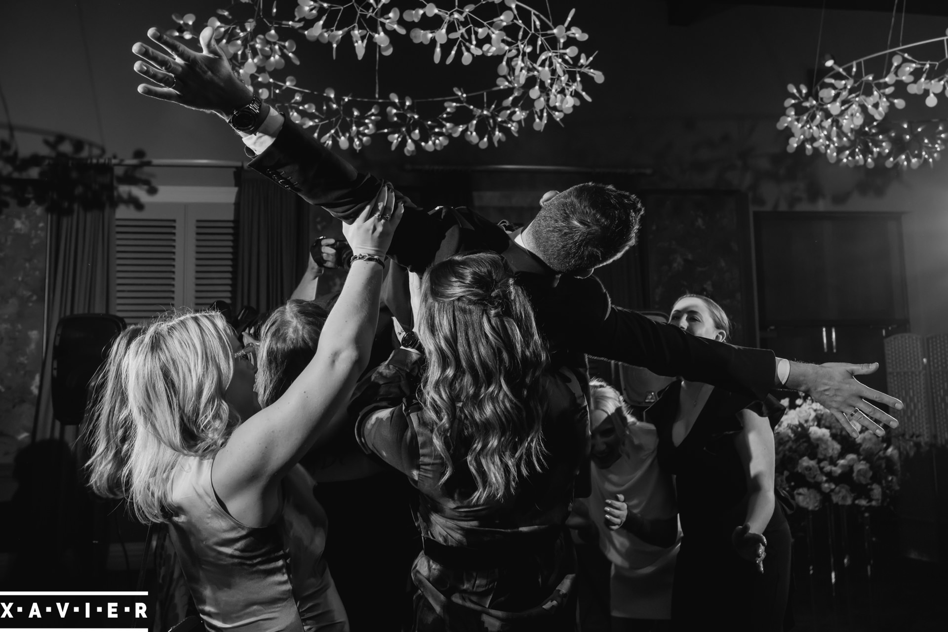 groom is lifted in the air