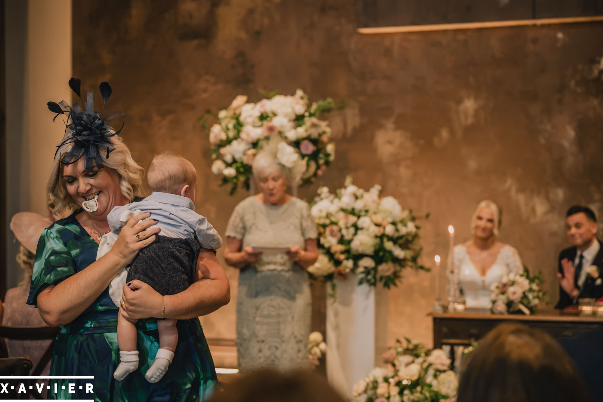 groom waves at the baby being carried away