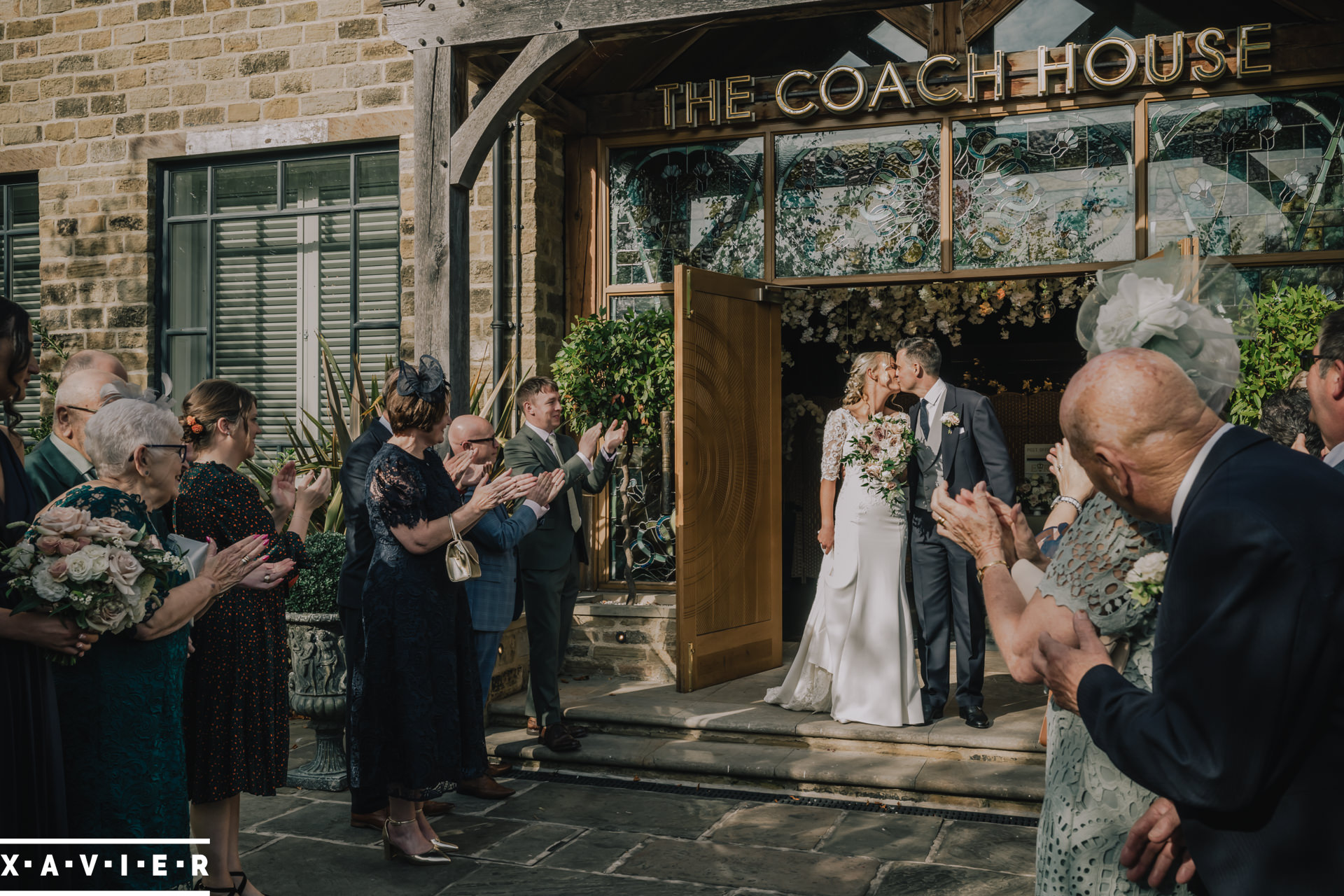bride and groom kiss on the confetti line