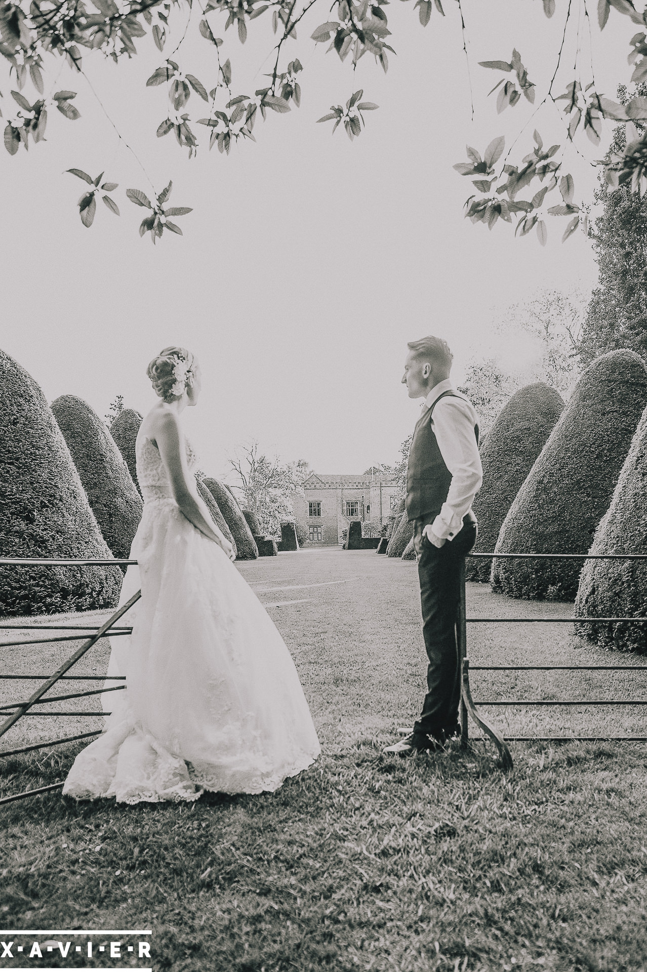 bride and groom stand together in the gardens