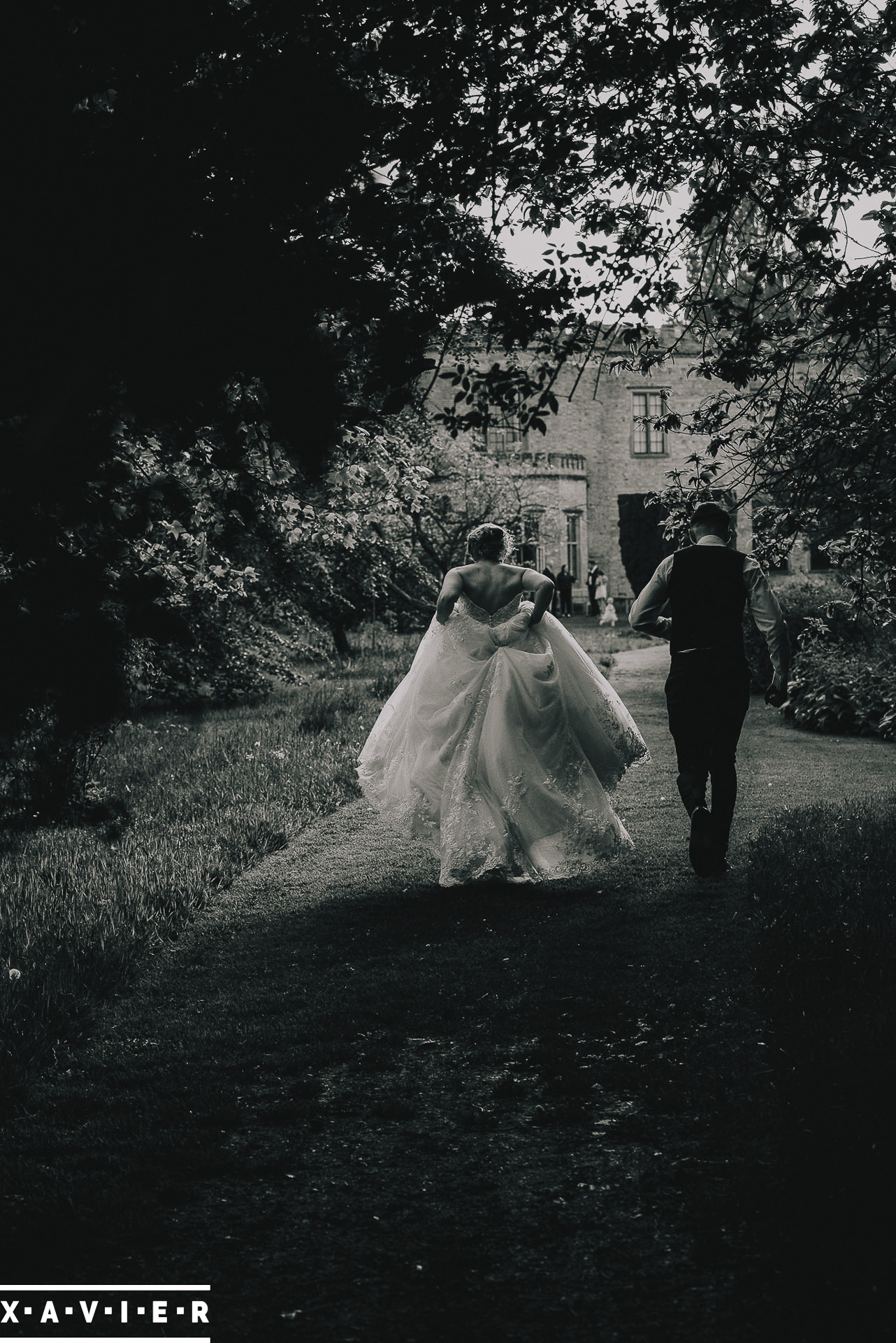 bride and groom walk under the trees