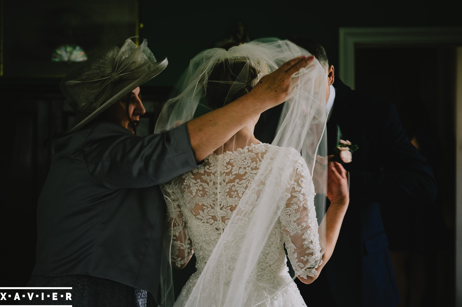 mother of the bride puts on the brides veil