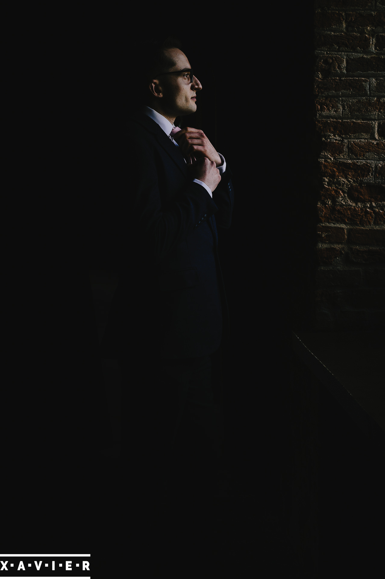 the groom adjusts his tie 