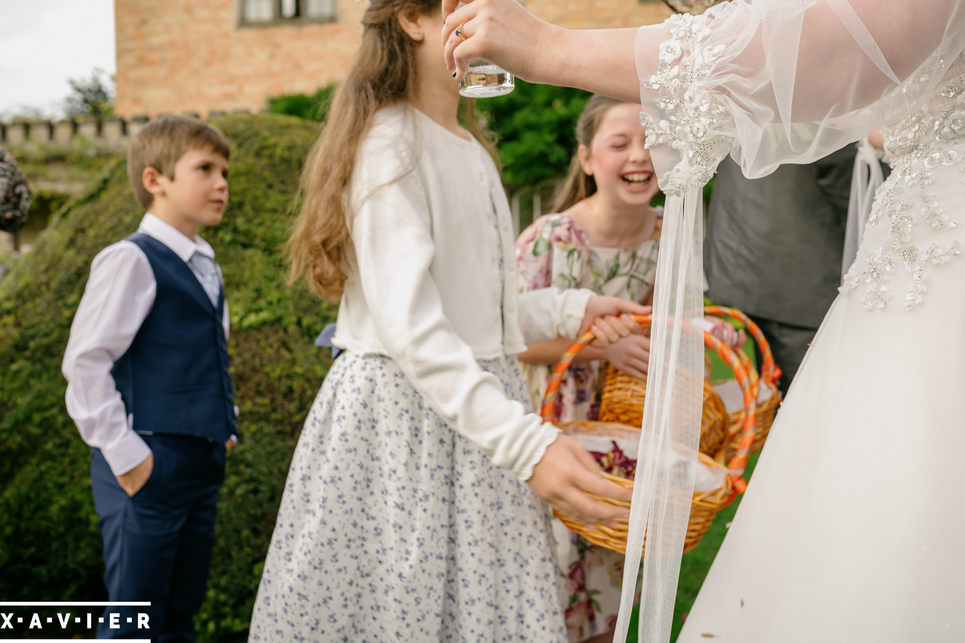 Flowergirl laughs excitedly as she greets the bride
