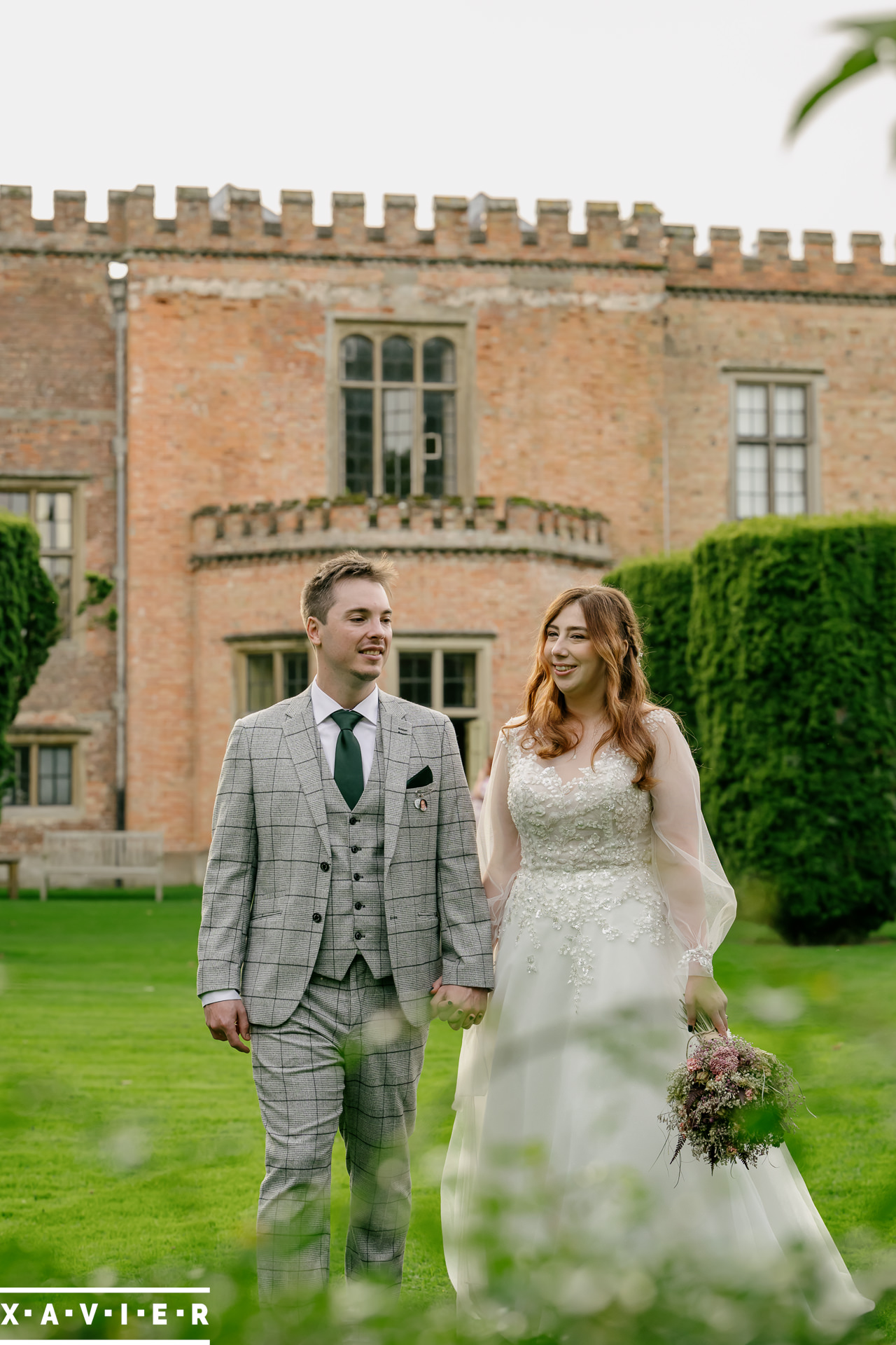 Bride and groom hold embrace in the gardens