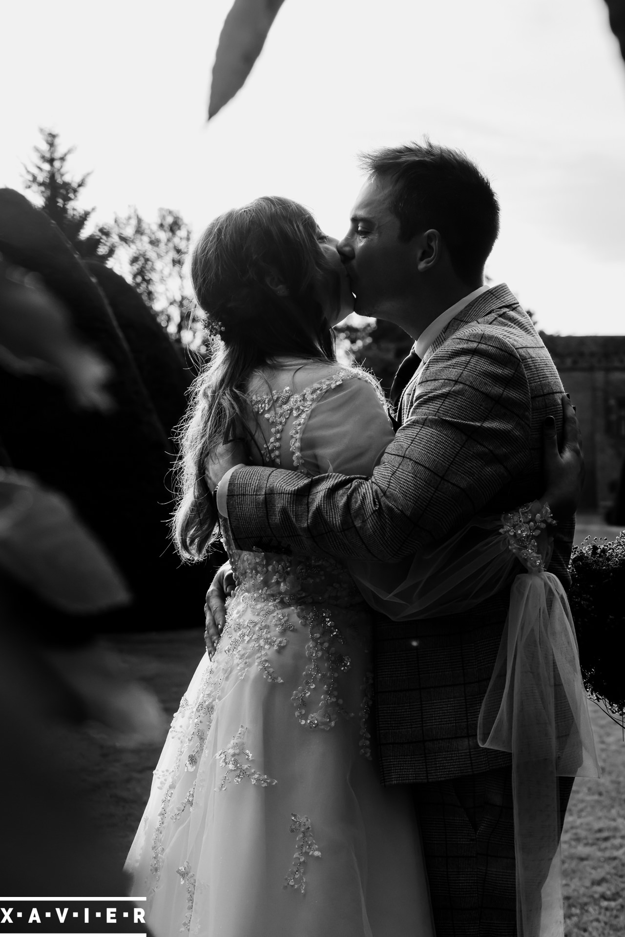 Bride and groom hold embrace in the gardens