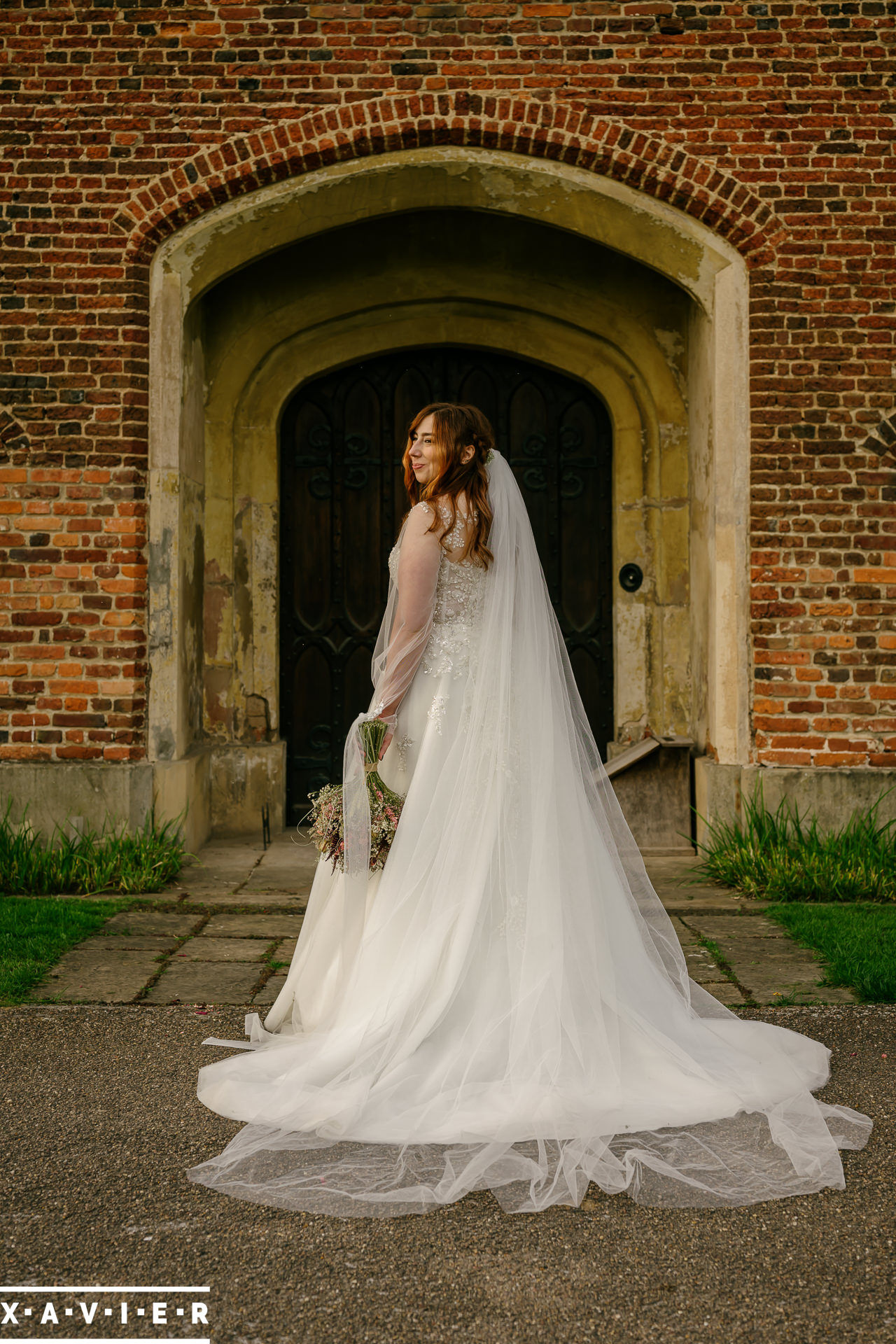Bride stands in front of the old front door