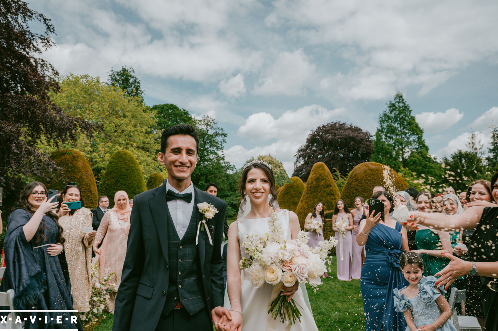 bride and groom walk down the confetti aisle