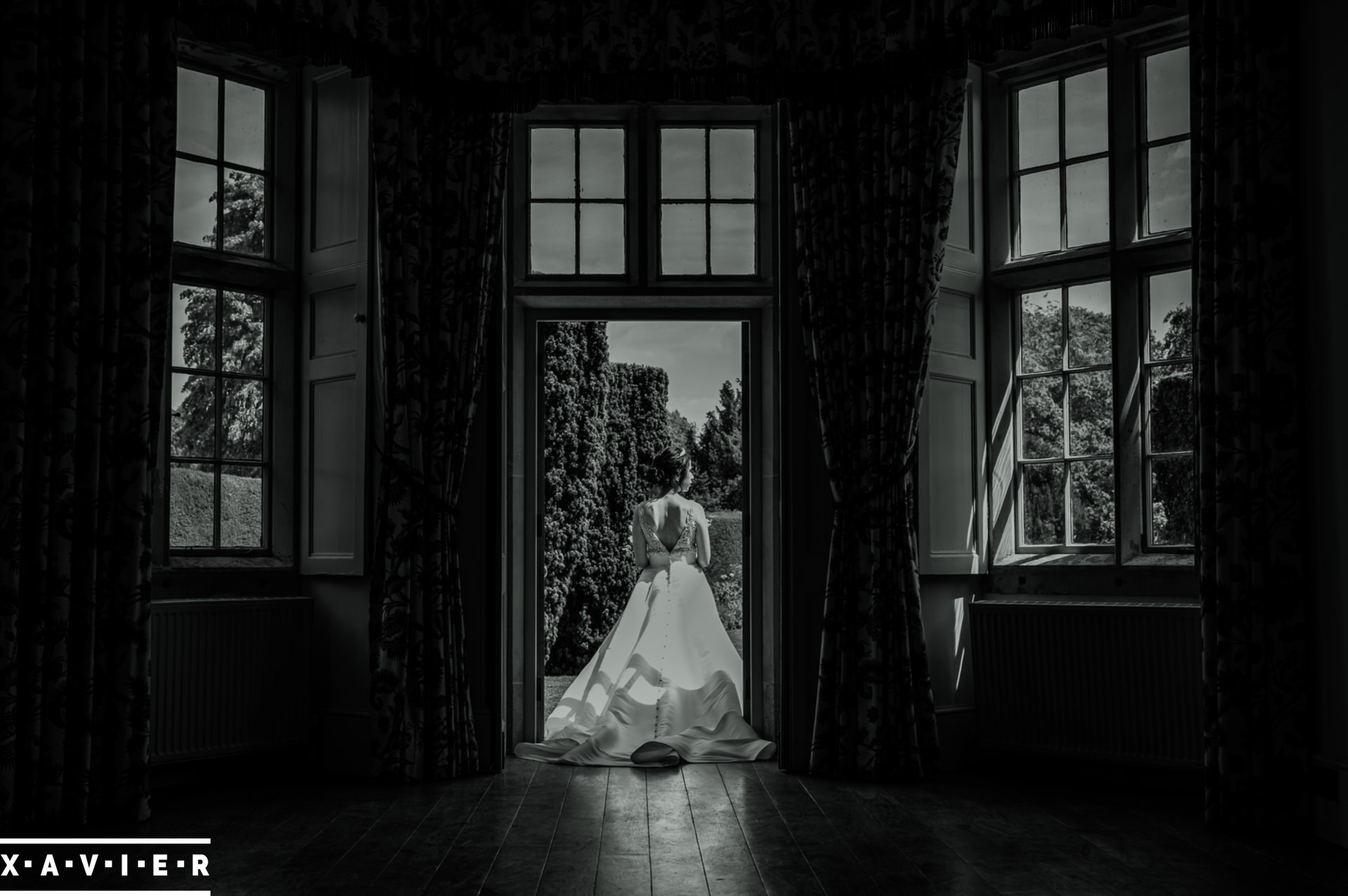 bride walks through the ball room into the gardens