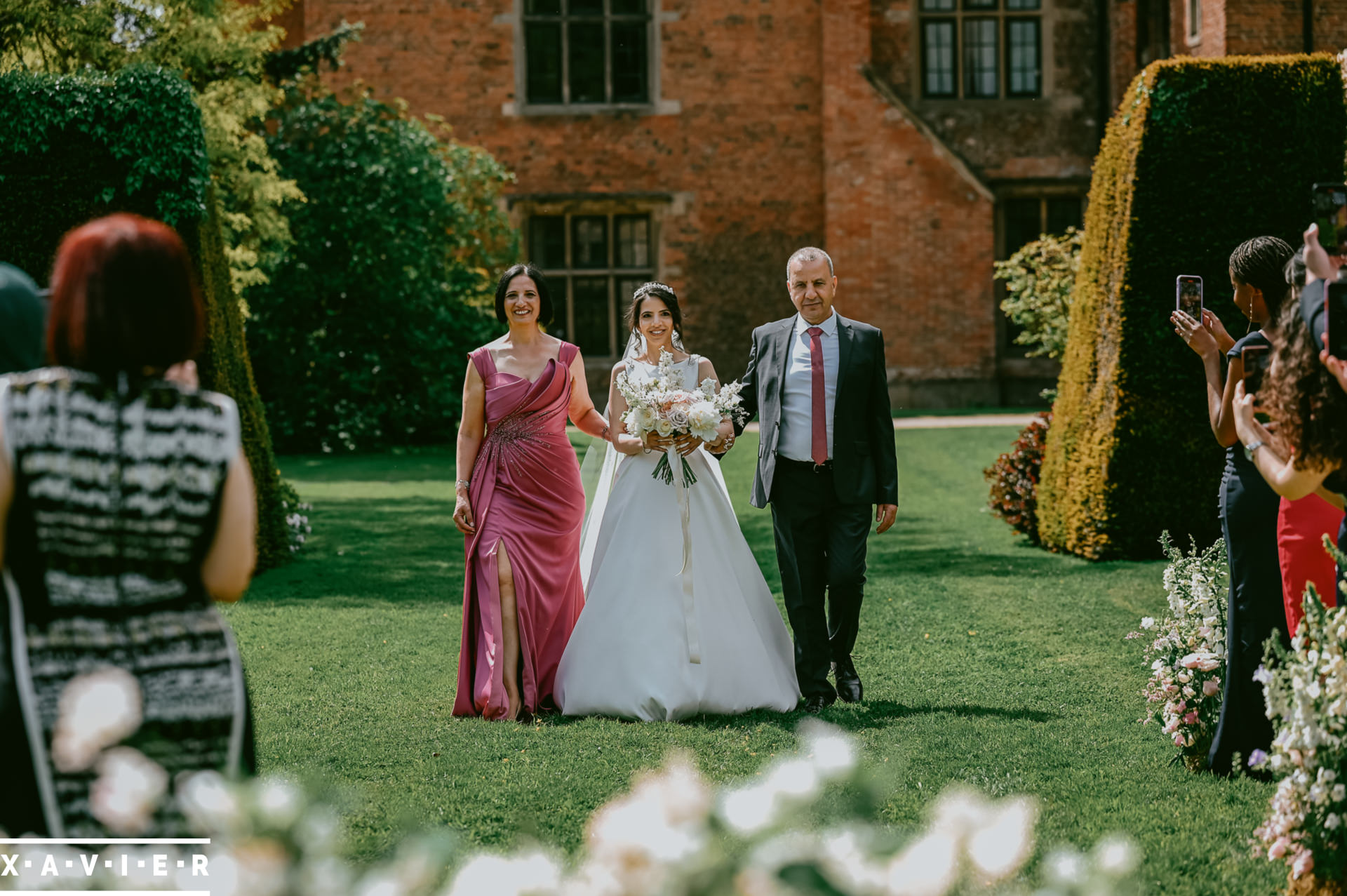 bride walks to the altar with her parents