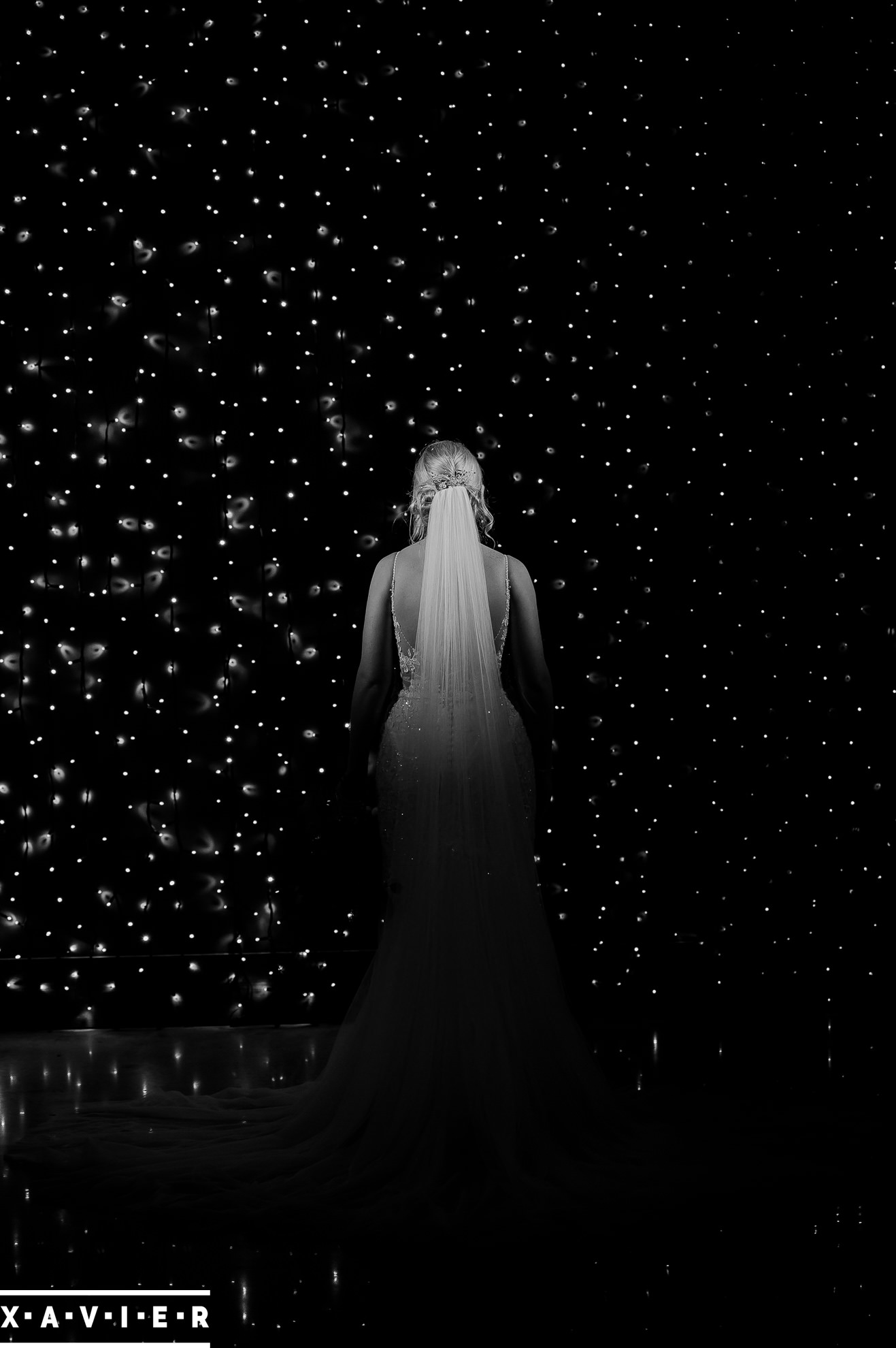 bride stands with her back to the camera at the glitter wall