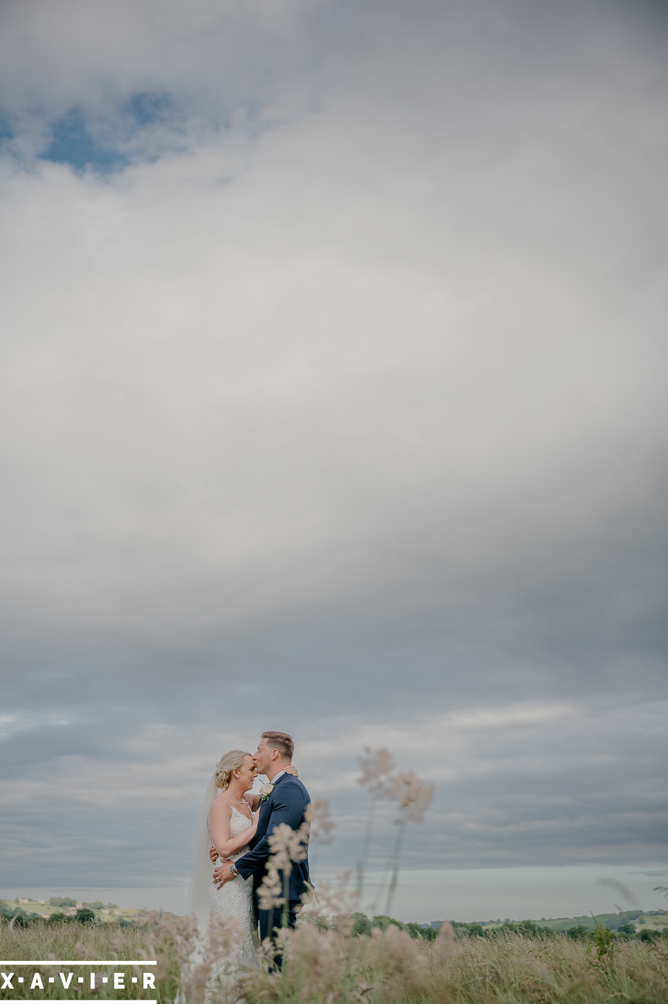bride and groom kissing in nearby fields