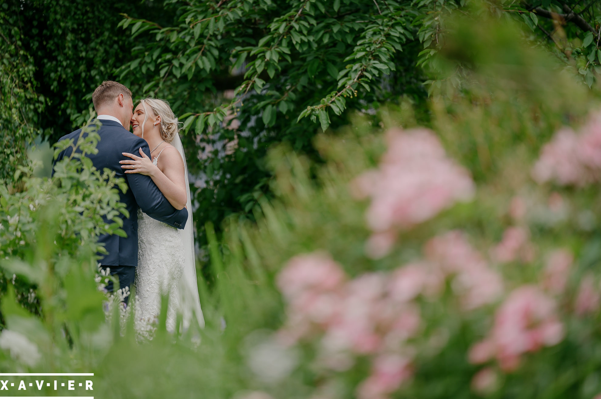 bride and groom embrace in the gardens