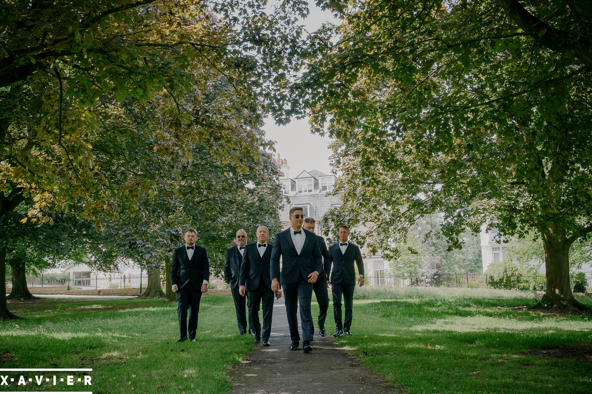 groomsmen walking through the park