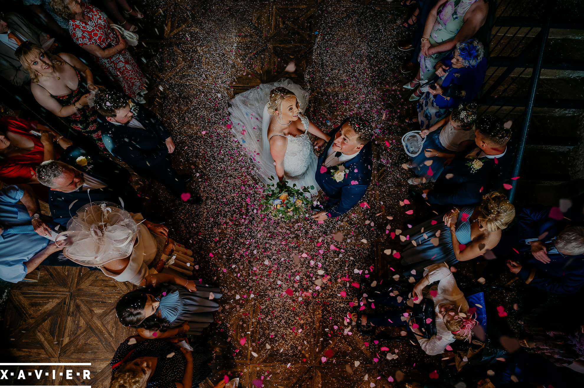 bride and groom look up at falling confetti