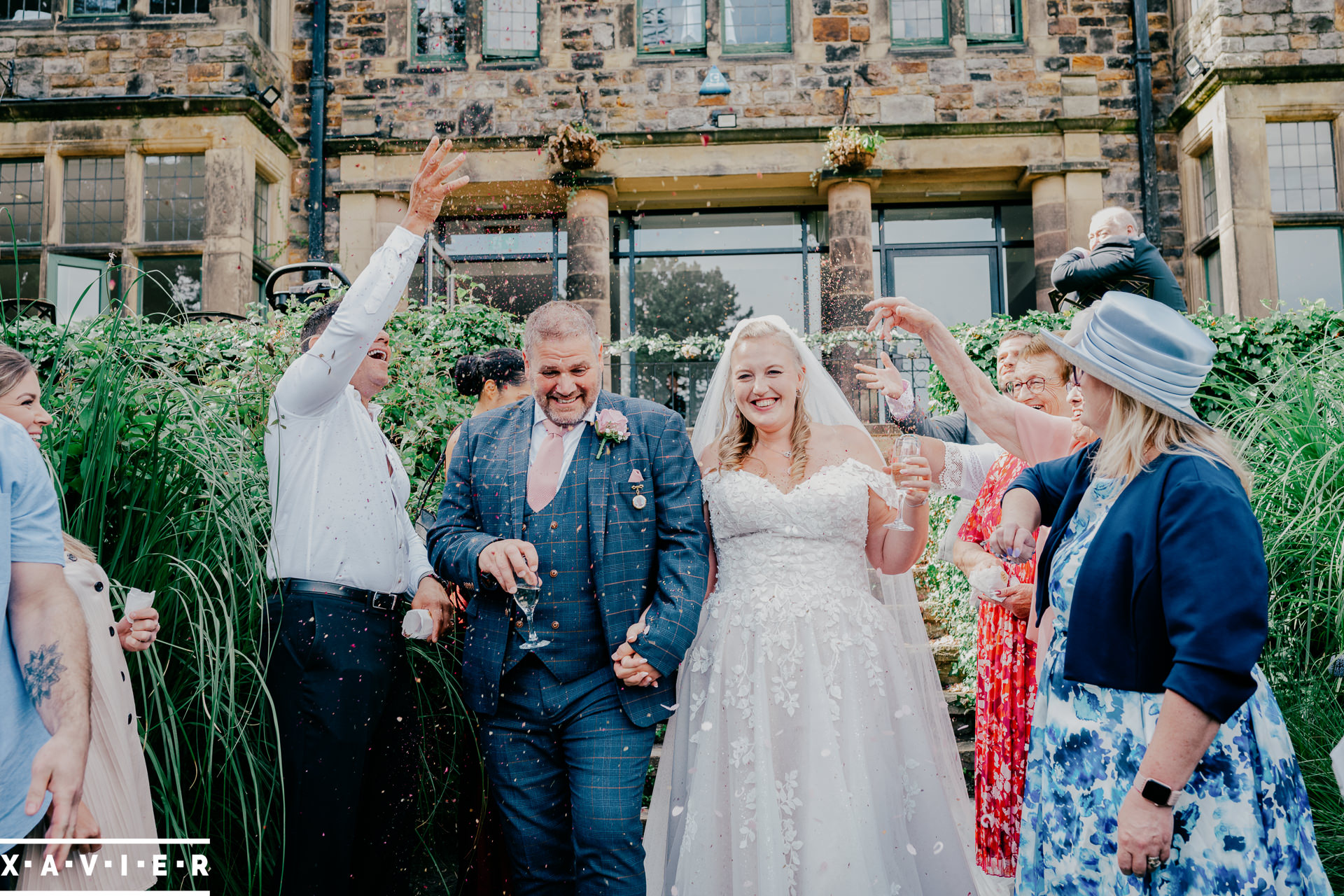 bride and groom walk through confetti