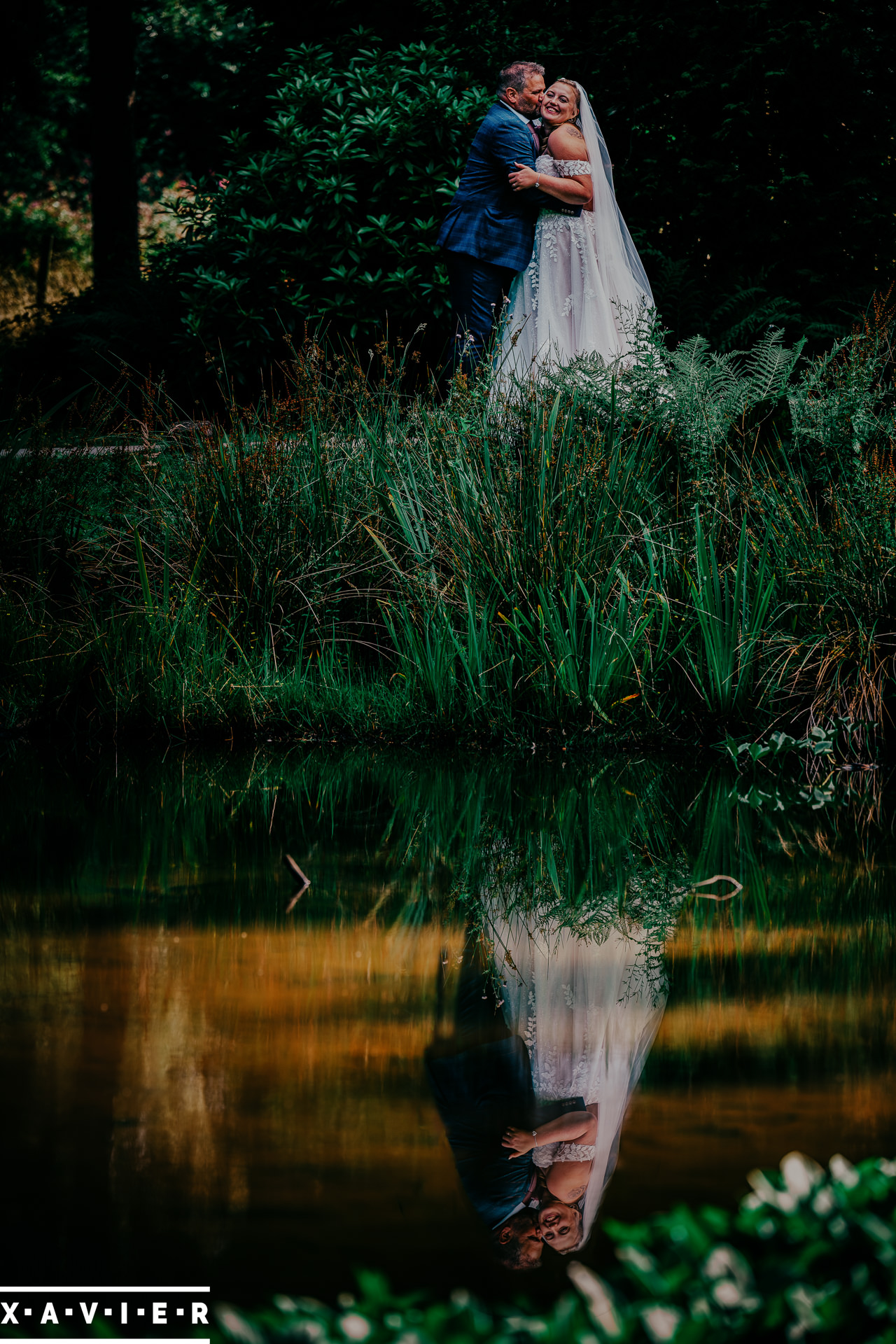 bride and groom with reflection in mill pond