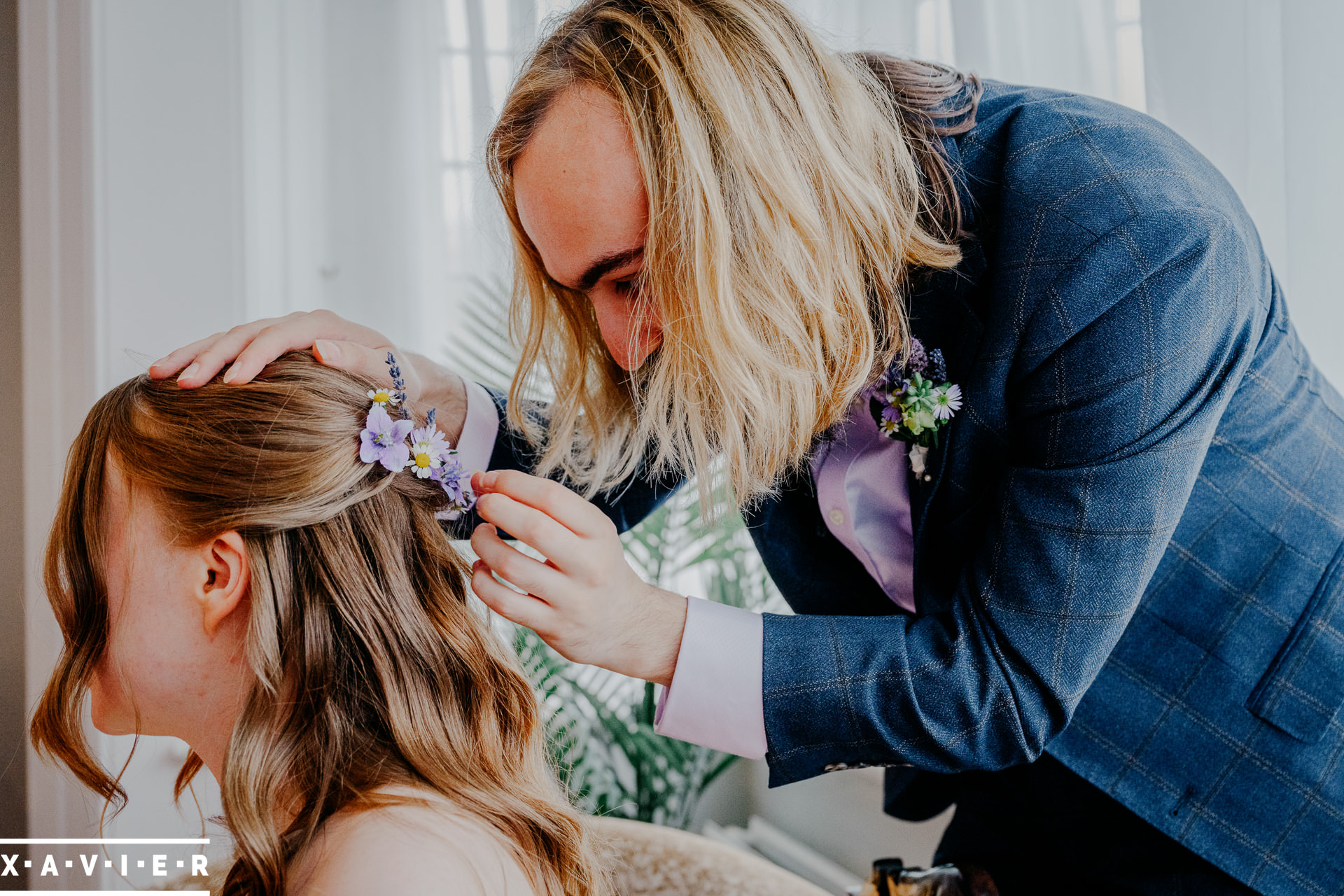 bride is having a flower slide put in her hair