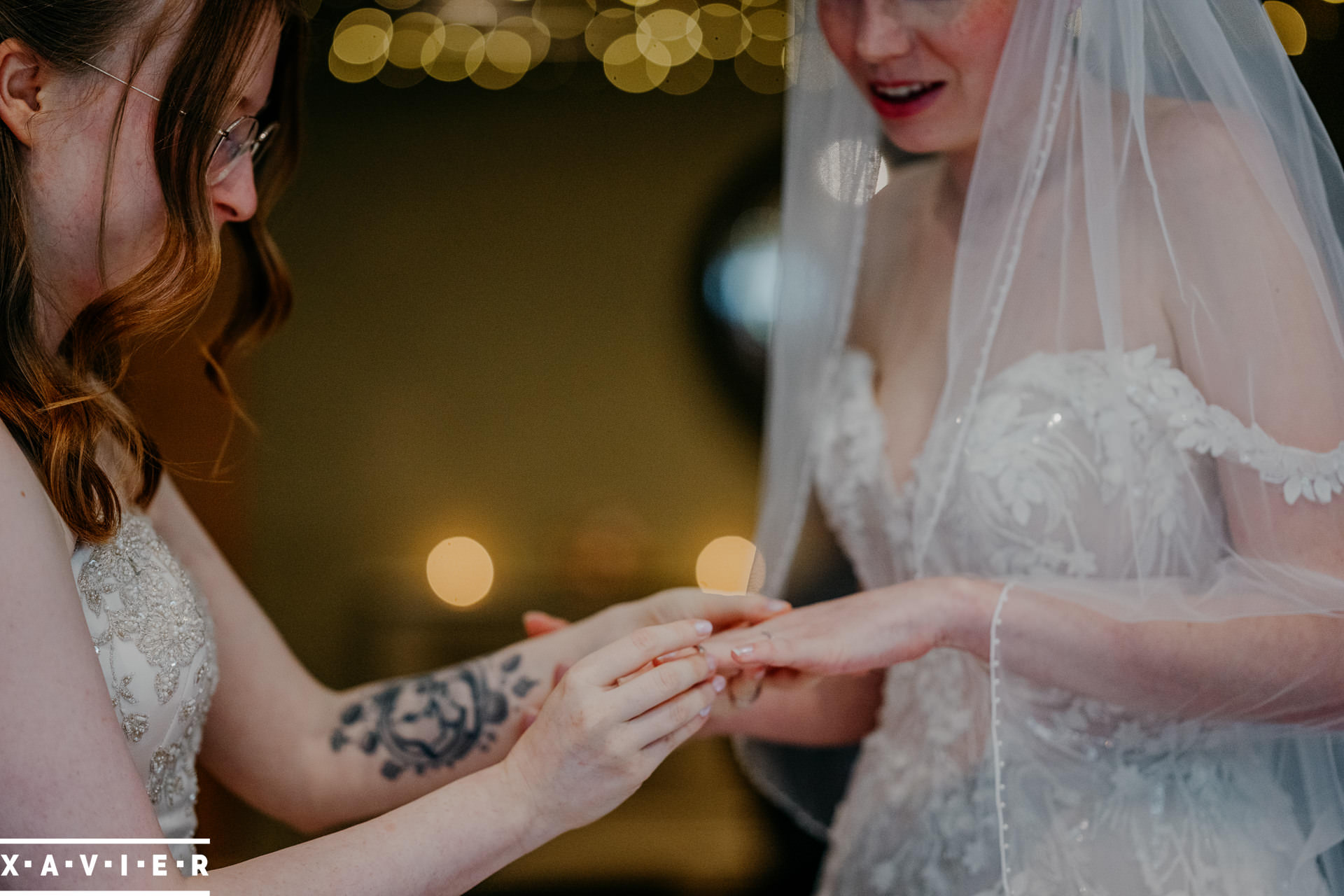 bride putting the wedding ring on her bride's finger